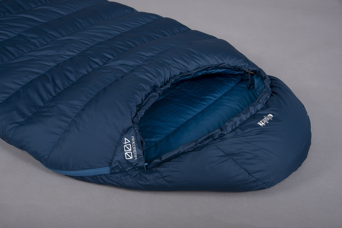 The hood of a Pipedream 400 lightweight 3 season sleeping bag in blue laid on the floor on a grey background