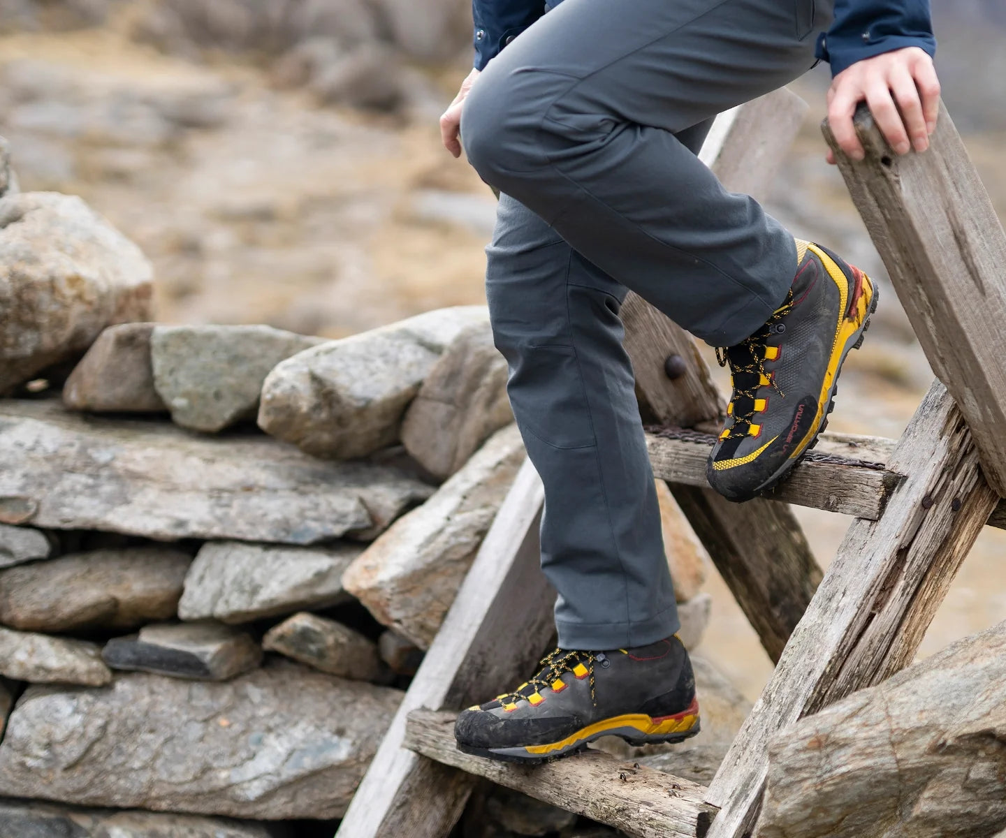 Hiker climbing over a style in welsh mountains