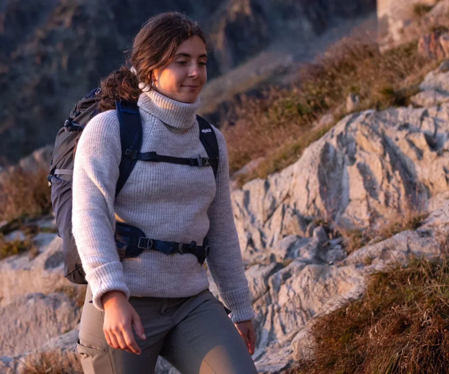 Woman hiking in the mountains in a wool jumper
