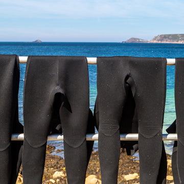 Outdoor swimmers entering the water in wetsuits