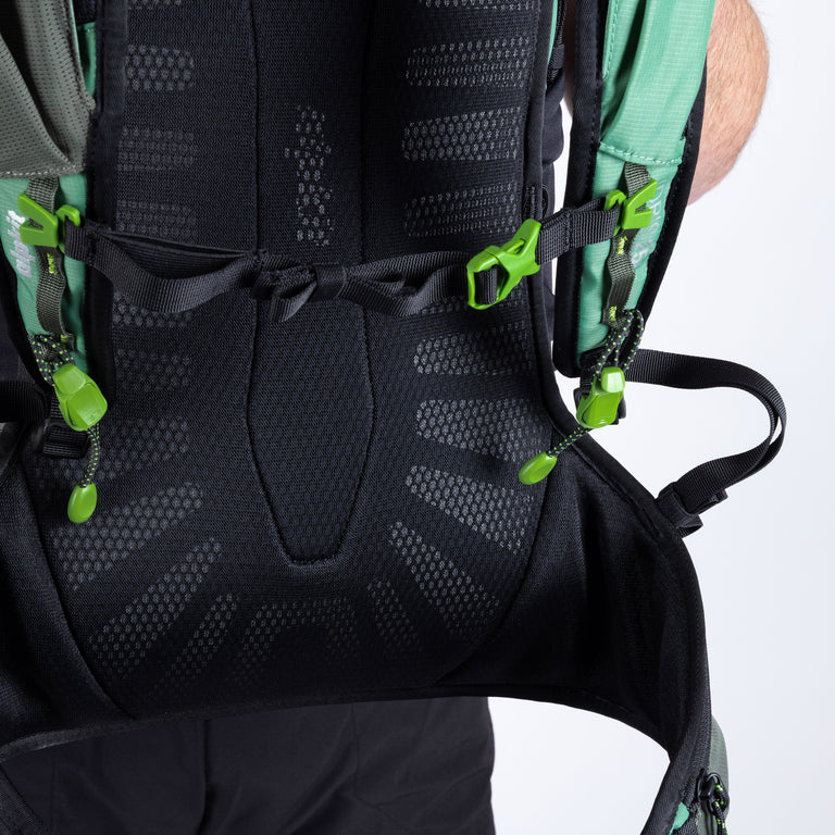 Close-up of a black backpack with green straps on a white background